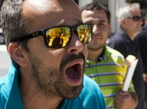 Donald Trump supporter yells at Muslim woman at a rally in Detroit. Photo by Steve Neavling. 